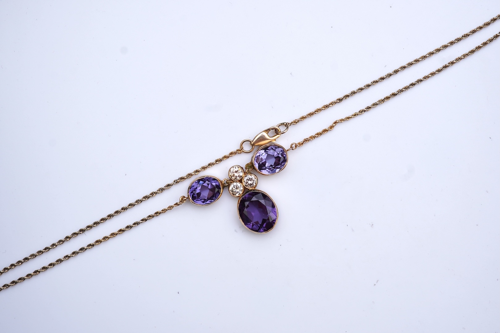 A synthetic colour-change sapphire and diamond pendant necklace
